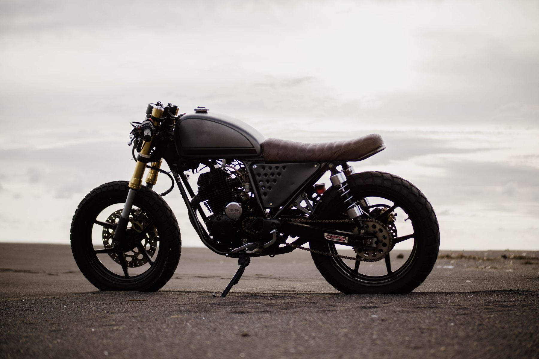 Custom Yamaha café racer parked facing the sea